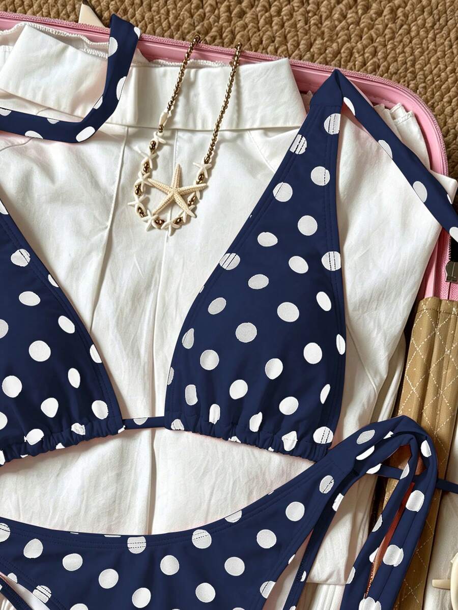 Women's polka dot two-piece bikini set featuring a backless halter top with triangle cups and matching tie-side bottoms.