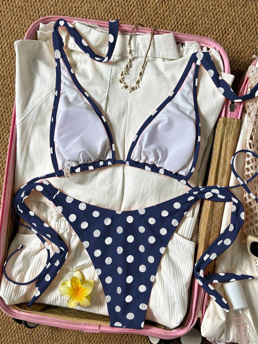 Women's polka dot two-piece bikini set featuring a backless halter top with triangle cups and matching tie-side bottoms.