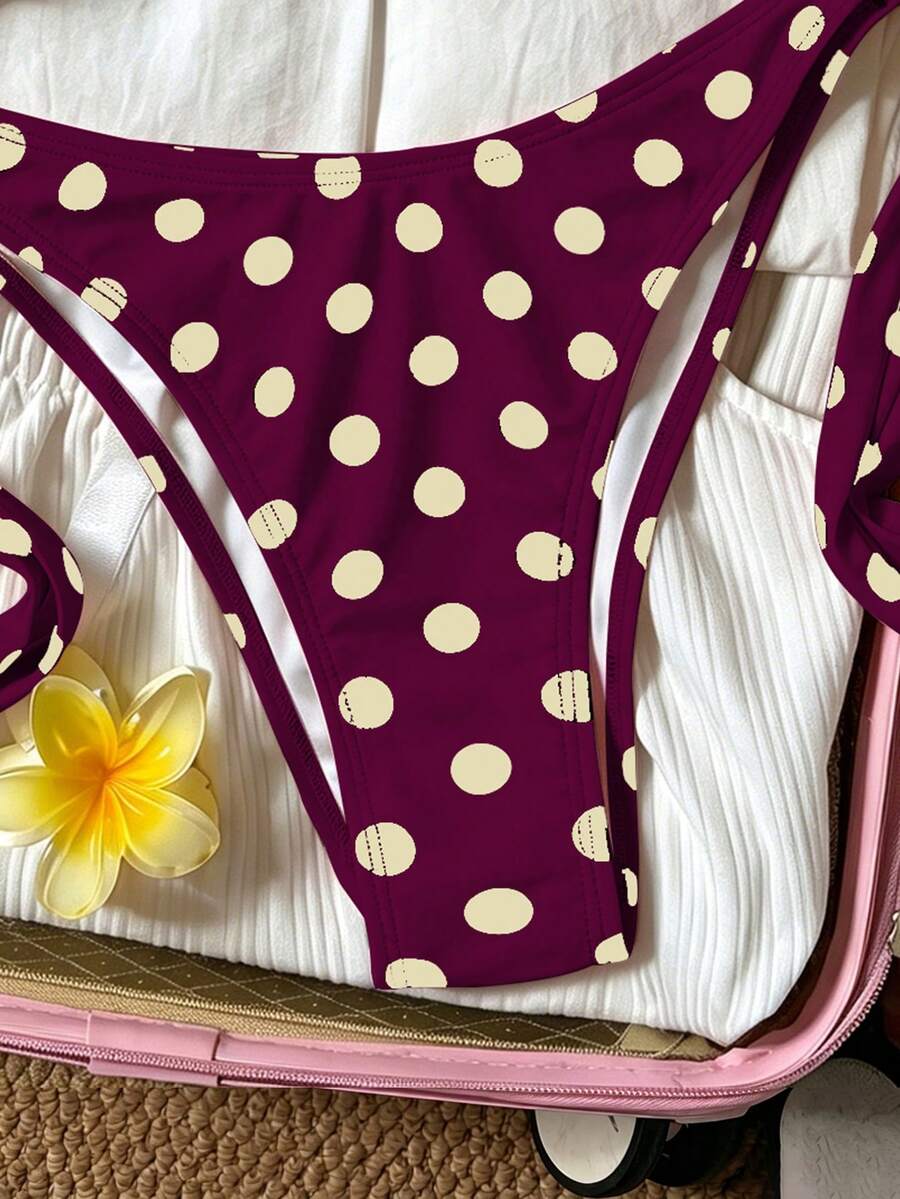 Women's polka dot two-piece bikini set featuring a backless halter top with triangle cups and matching tie-side bottoms.