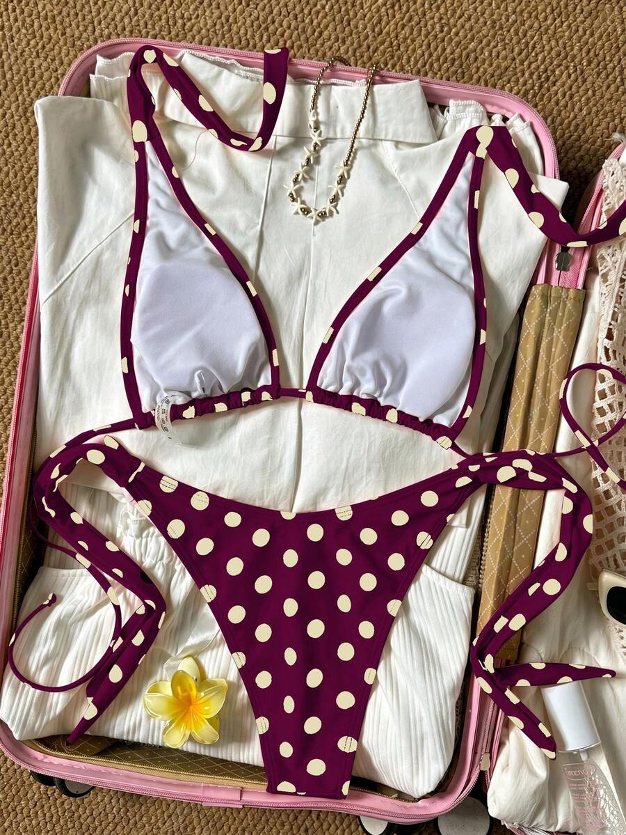 Women's polka dot two-piece bikini set featuring a backless halter top with triangle cups and matching tie-side bottoms.