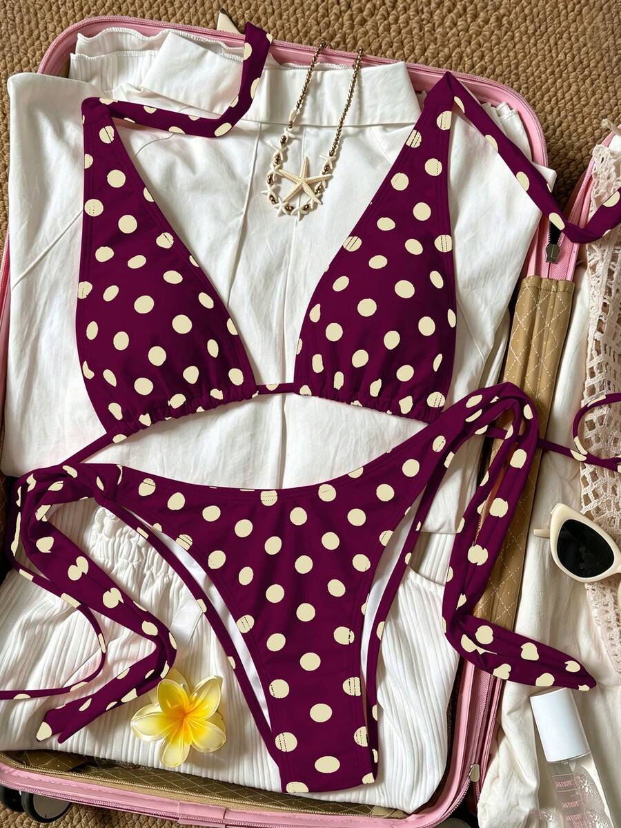 Women's polka dot two-piece bikini set featuring a backless halter top with triangle cups and matching tie-side bottoms.