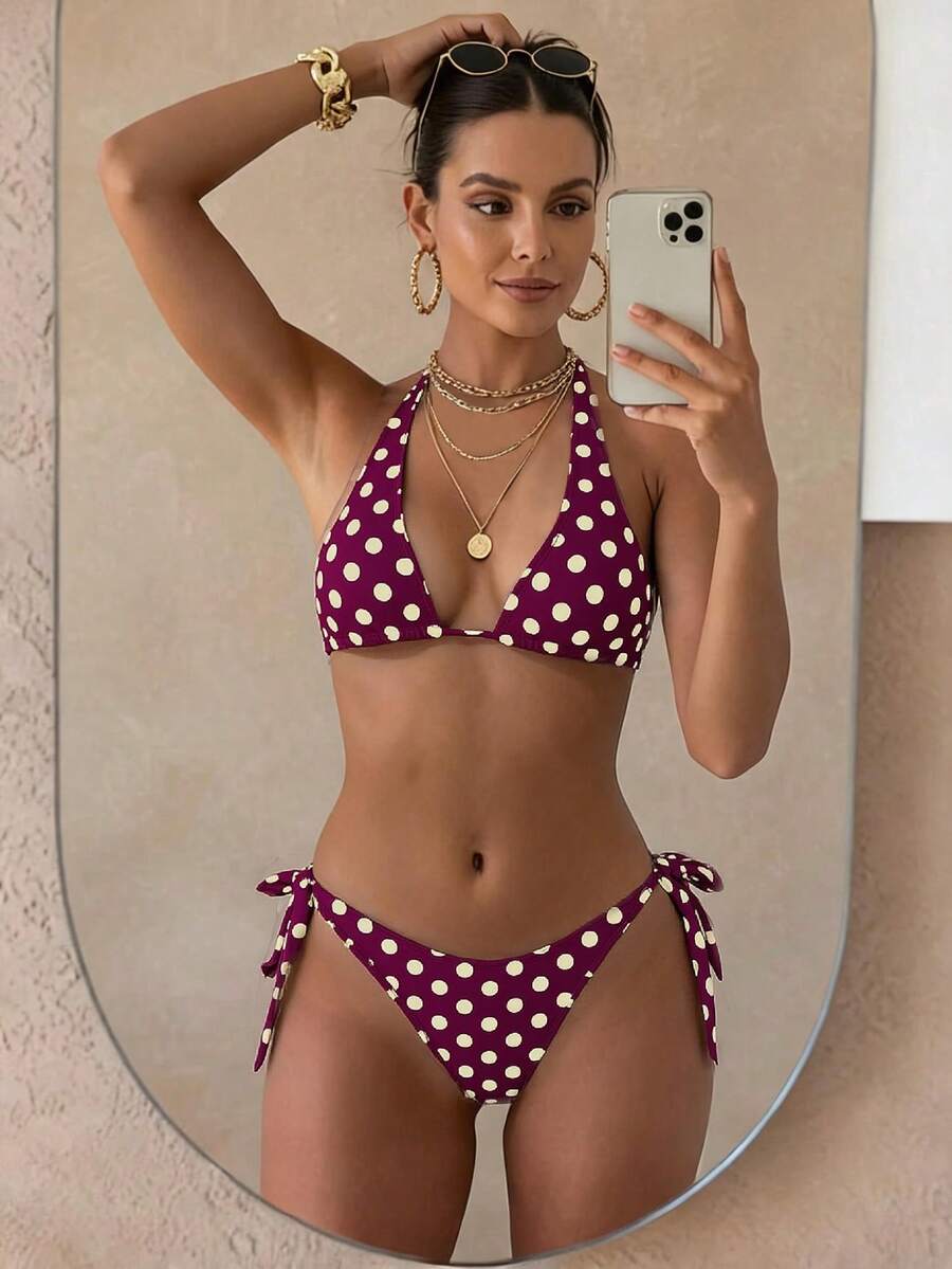 Women's polka dot two-piece bikini set featuring a backless halter top with triangle cups and matching tie-side bottoms.