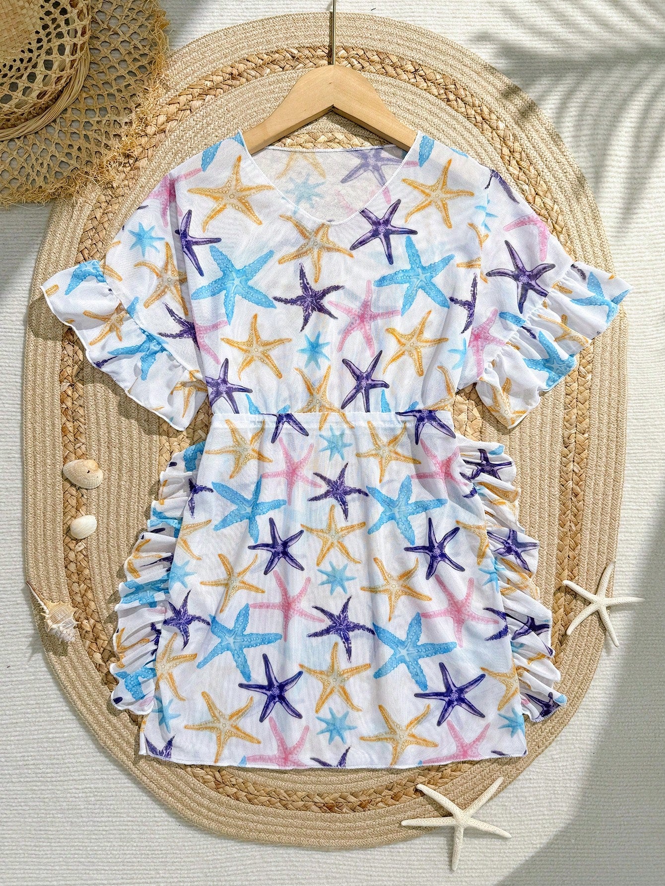 Blue tween girls swimsuit cover up with geometric starfish print, ruffle trim, round neck, short sleeves, and semi-sheer knit fabric for beach or pool wear.