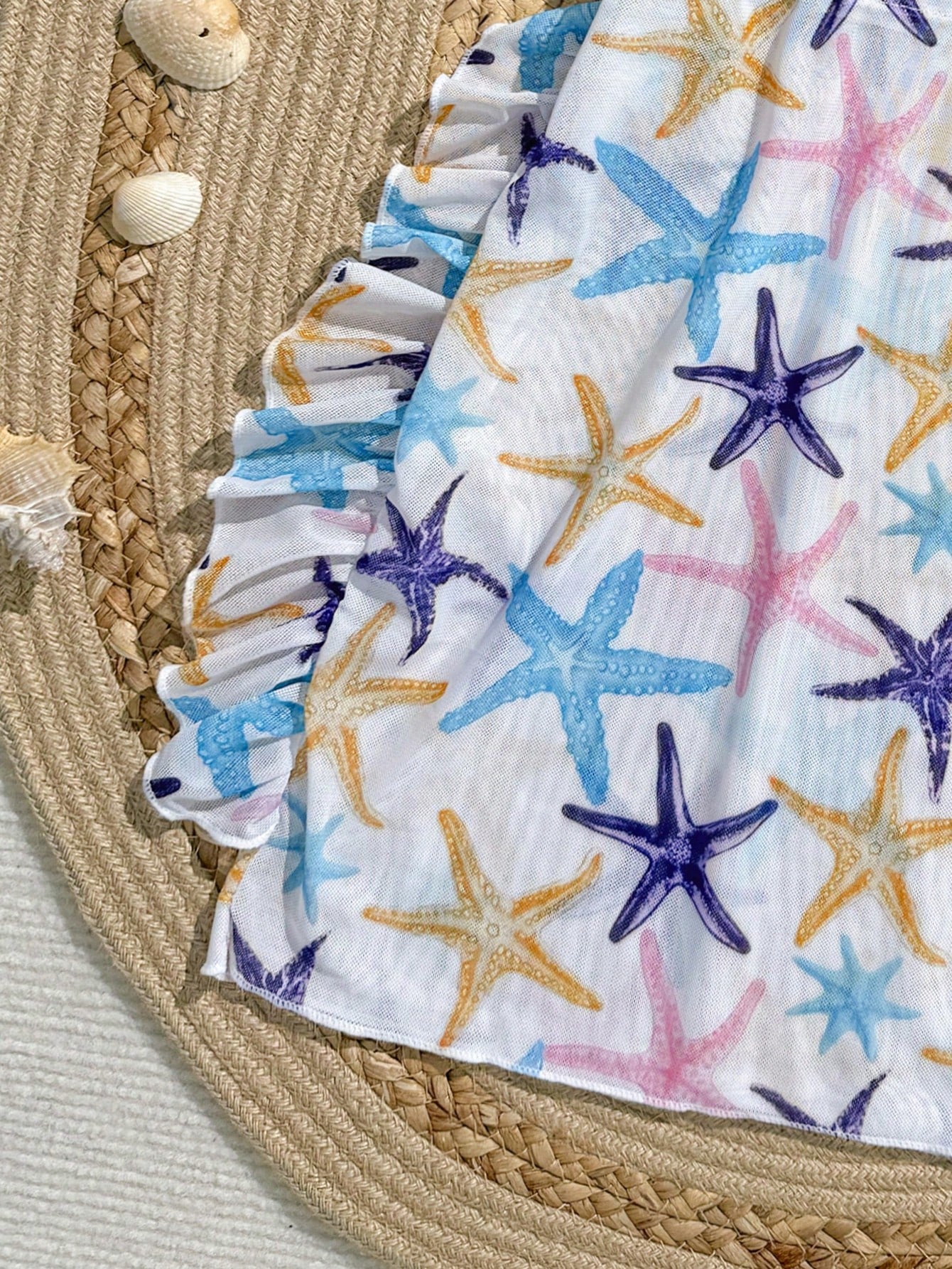 Blue tween girls swimsuit cover up with geometric starfish print, ruffle trim, round neck, short sleeves, and semi-sheer knit fabric for beach or pool wear.