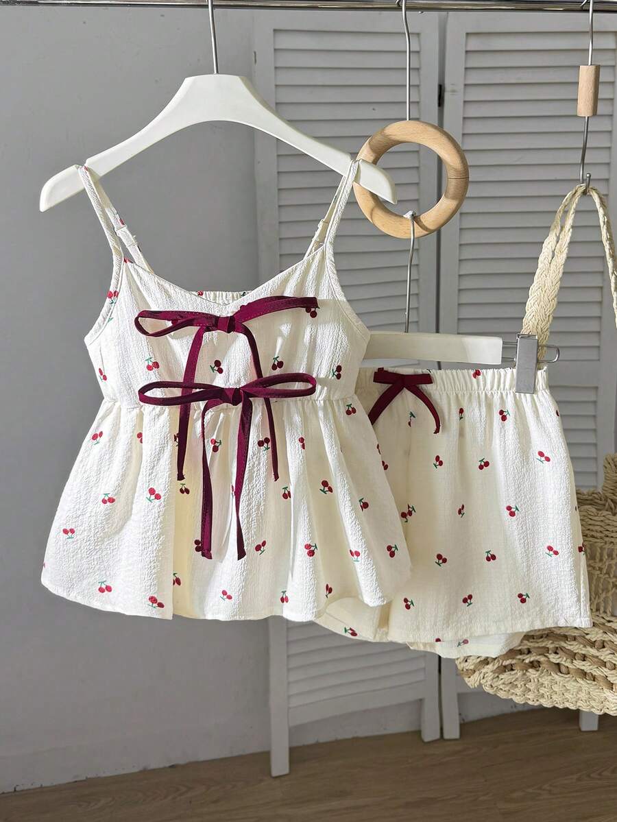 Tween girls 2-piece summer vacation set featuring a multicolored geometric print sleeveless camisole top with bow knot detail and matching elastic waist shorts.