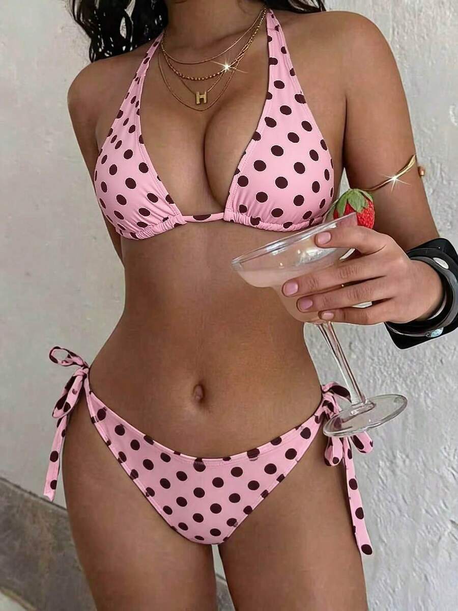 Women's polka dot two-piece bikini set featuring a backless halter top with triangle cups and matching tie-side bottoms.