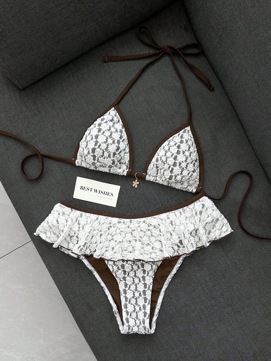 Women's 70s retro black and white polka dot bikini set featuring a halter triangle top and ultra low waist bottoms.