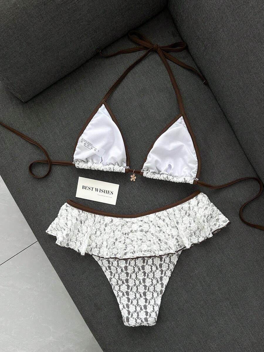 Women's 70s retro black and white polka dot bikini set featuring a halter triangle top and ultra low waist bottoms.