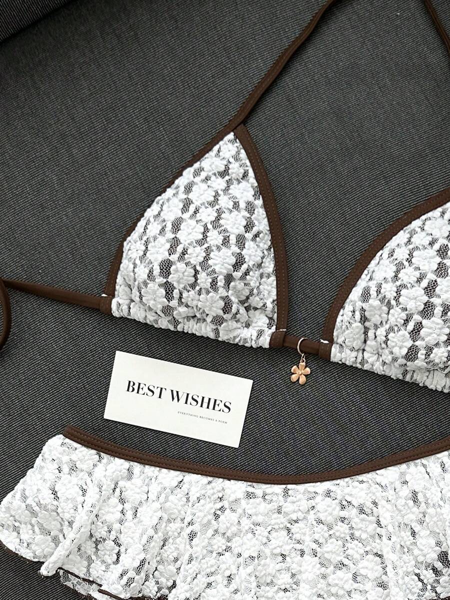 Women's 70s retro black and white polka dot bikini set featuring a halter triangle top and ultra low waist bottoms.