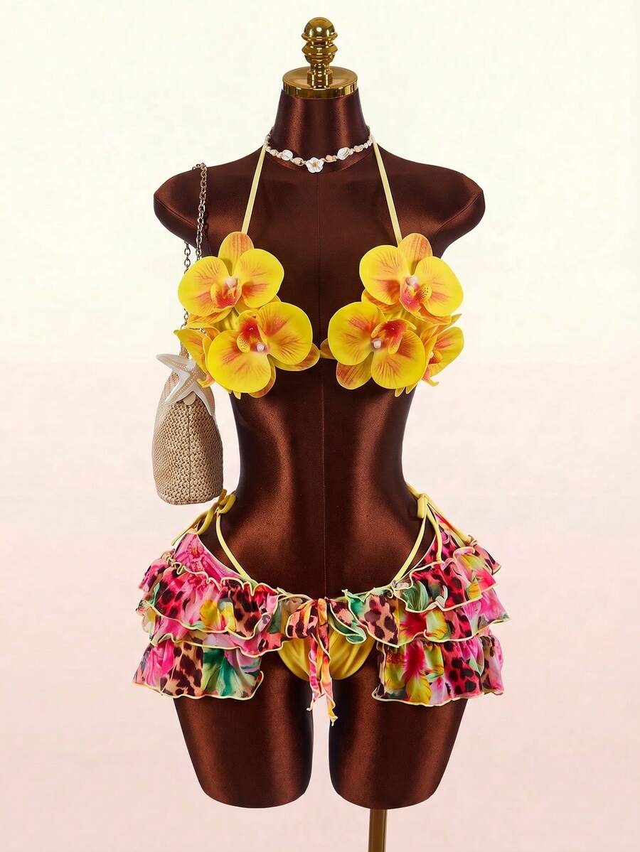Women's 3-piece blue bikini swimwear set featuring a crop top with 3D rose accents, tie back detail, spaghetti straps, and tie-side bottoms.