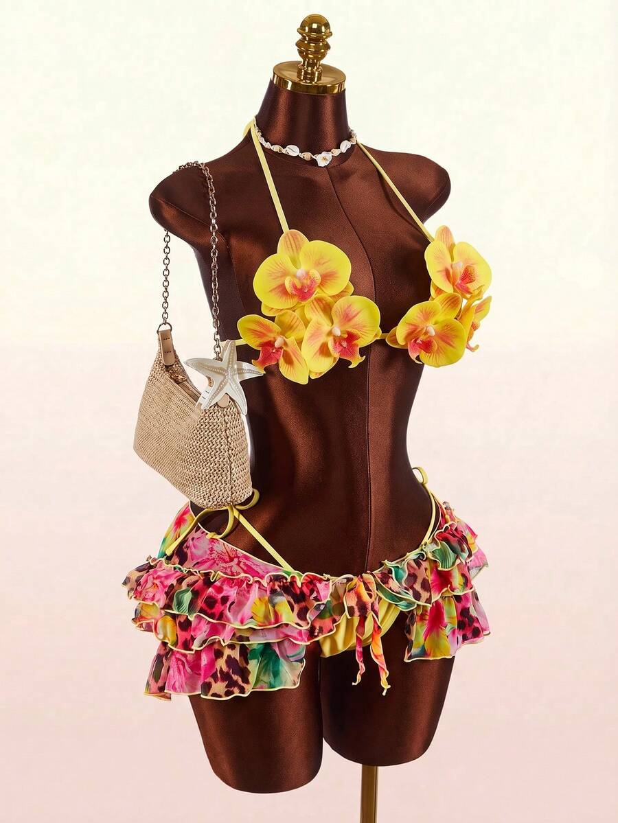 Women's 3-piece blue bikini swimwear set featuring a crop top with 3D rose accents, tie back detail, spaghetti straps, and tie-side bottoms.