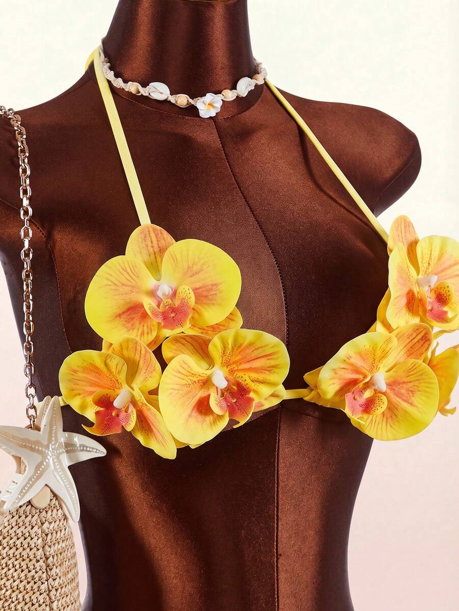 Women's 3-piece blue bikini swimwear set featuring a crop top with 3D rose accents, tie back detail, spaghetti straps, and tie-side bottoms.