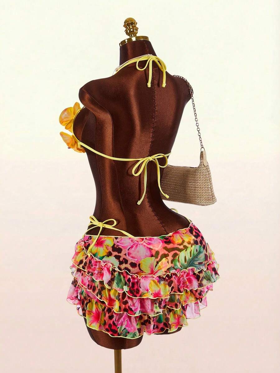 Women's 3-piece blue bikini swimwear set featuring a crop top with 3D rose accents, tie back detail, spaghetti straps, and tie-side bottoms.