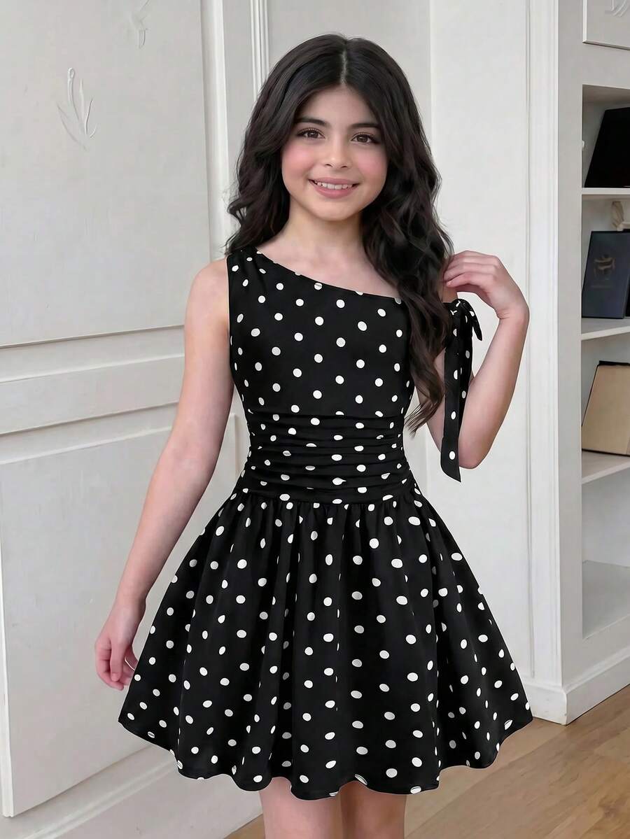 Tween girl wearing an apricot asymmetrical tiered sleeveless party dress with an A-line silhouette.