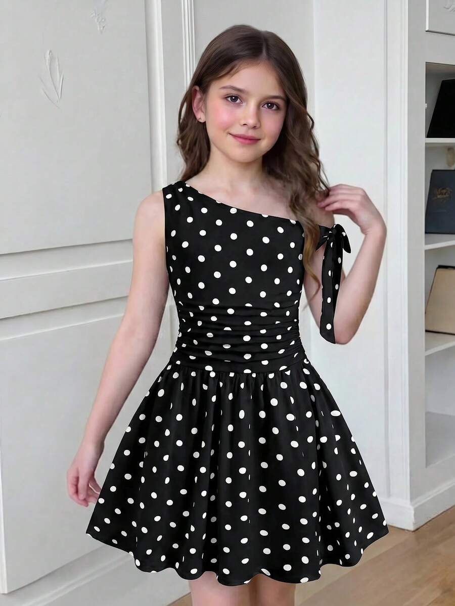 Tween girl wearing an apricot asymmetrical tiered sleeveless party dress with an A-line silhouette.
