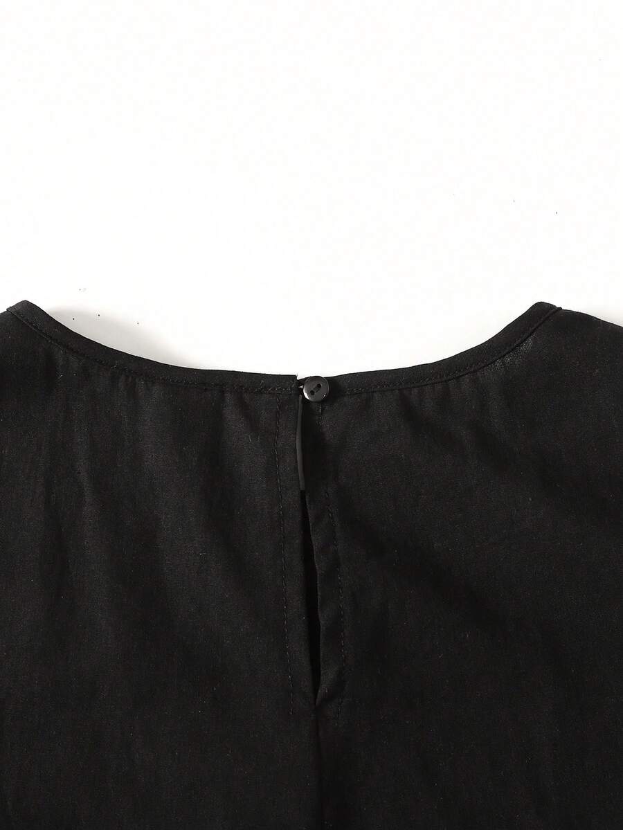 Tween girl wearing a sleeveless black tunic dress featuring a round neck, contrast lace details, and a straight hem.