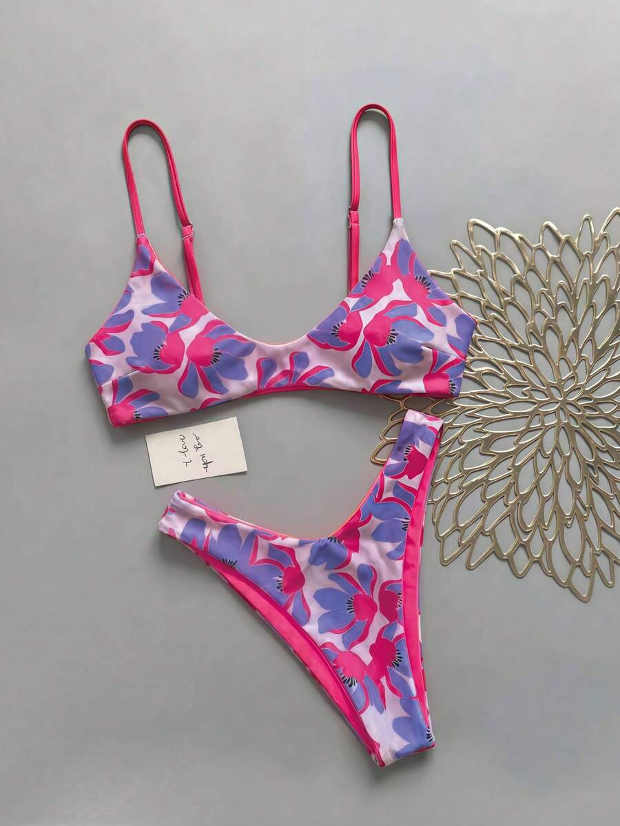 Women's pinkish orange floral print 2-piece bikini set featuring a backless wireless top with spaghetti straps and matching mid-waist bikini bottoms.