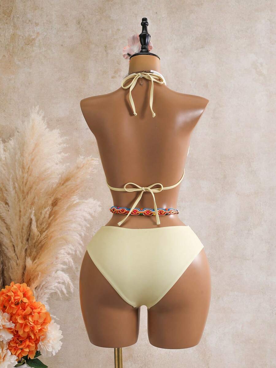 Women's black 3-piece bikini set featuring a halter triangle top with removable padding, high-waisted bottoms, and a knee-length mesh skirt with tie details.