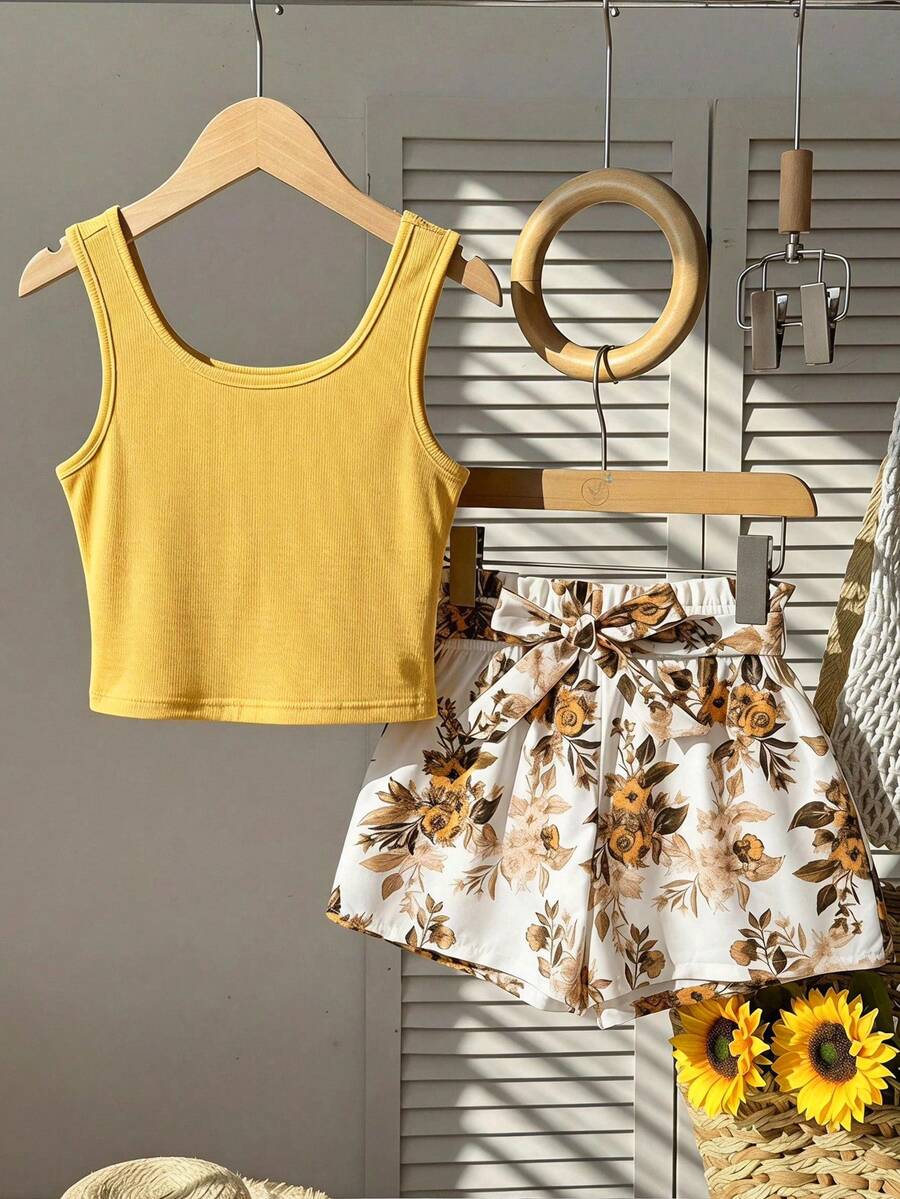 Tween girl wearing a casual 2-piece set featuring a black rib-knit scoop neck tank top and leopard print paperbag waist shorts with a matching belt.