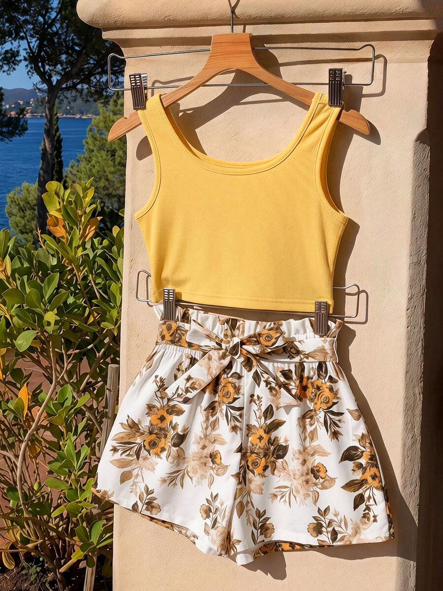 Tween girl wearing a casual 2-piece set featuring a black rib-knit scoop neck tank top and leopard print paperbag waist shorts with a matching belt.