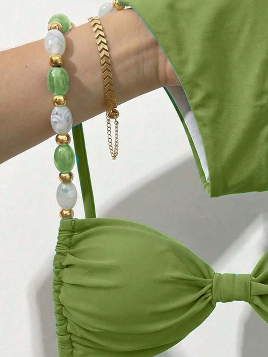 Women's green halter neck bikini set featuring color-block beaded shoulder straps, back tie detail, and high cut bottoms.