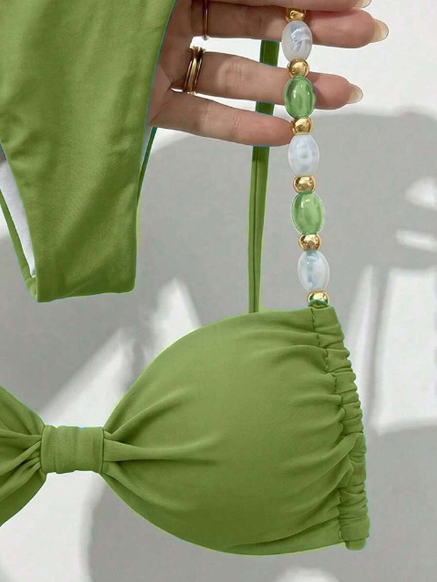 Women's green halter neck bikini set featuring color-block beaded shoulder straps, back tie detail, and high cut bottoms.