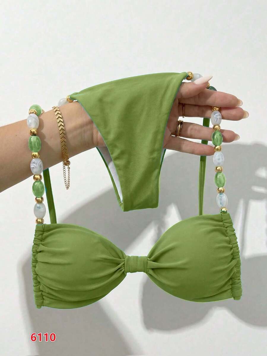 Women's green halter neck bikini set featuring color-block beaded shoulder straps, back tie detail, and high cut bottoms.