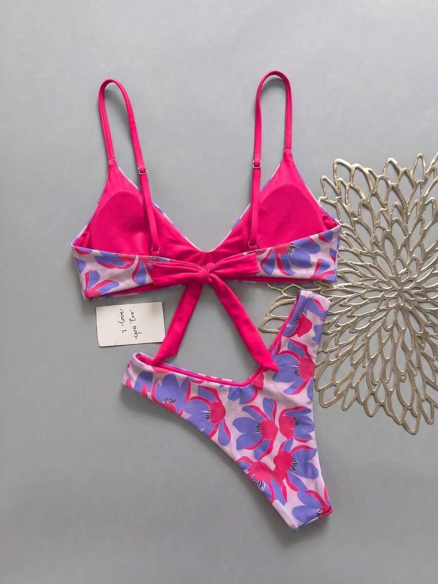 Women's pinkish orange floral print 2-piece bikini set featuring a backless wireless top with spaghetti straps and matching mid-waist bikini bottoms.