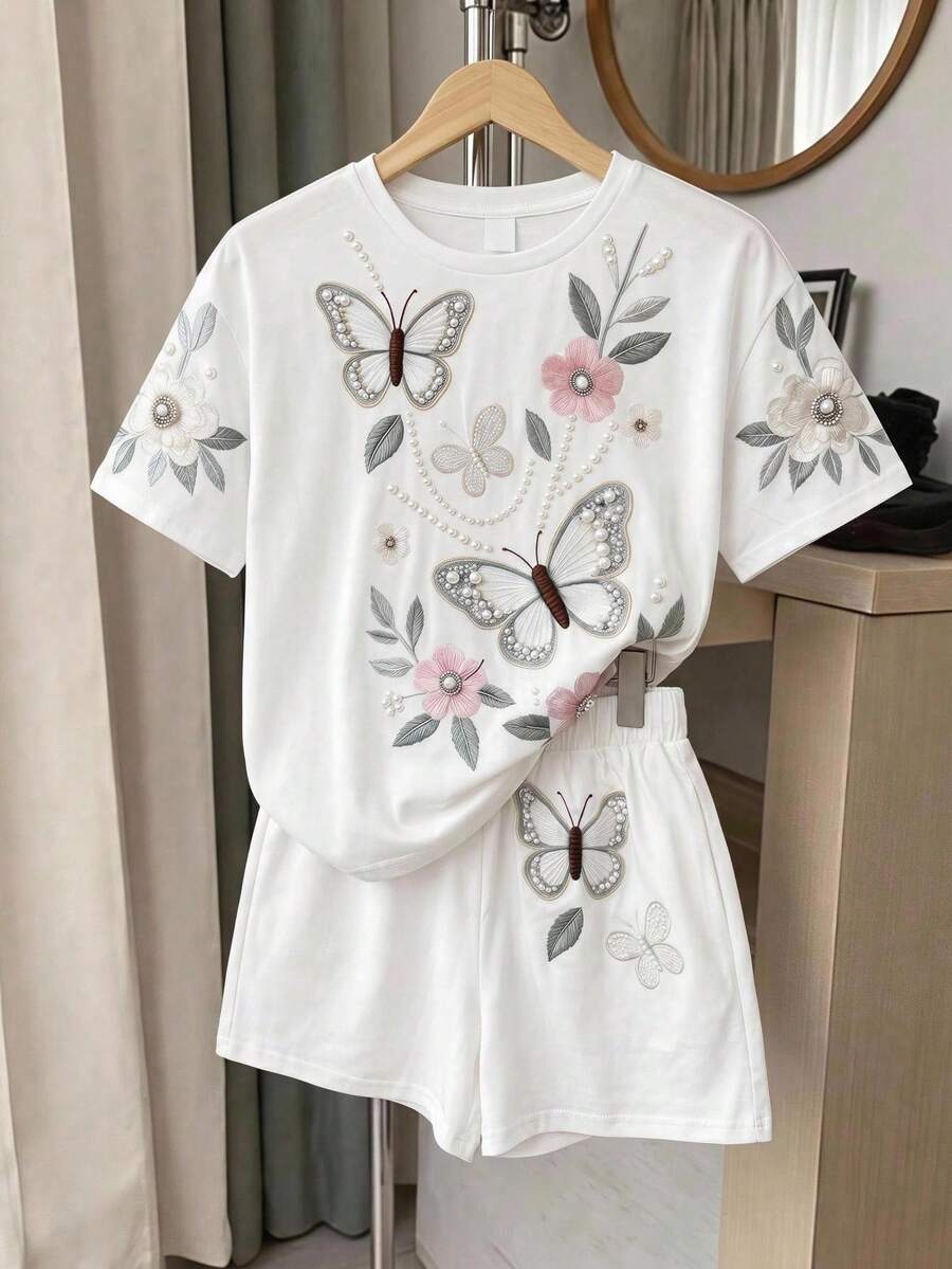 Tween girl wearing a black and white striped drop-shoulder crew neck t-shirt with bow embroidery paired with matching tie-waist shorts.
