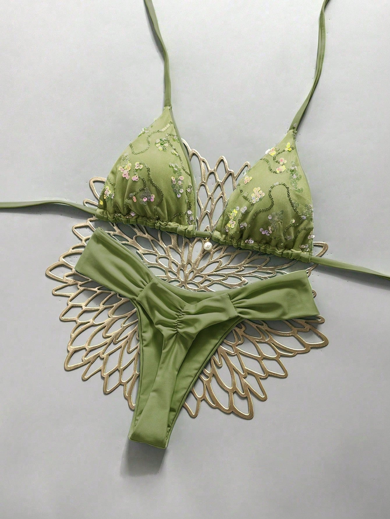 Women's 2-piece triangle cup bikini set in solid color featuring woven pearl shell decoration, halter neckline, and high-waist side-tie ruched bottoms.