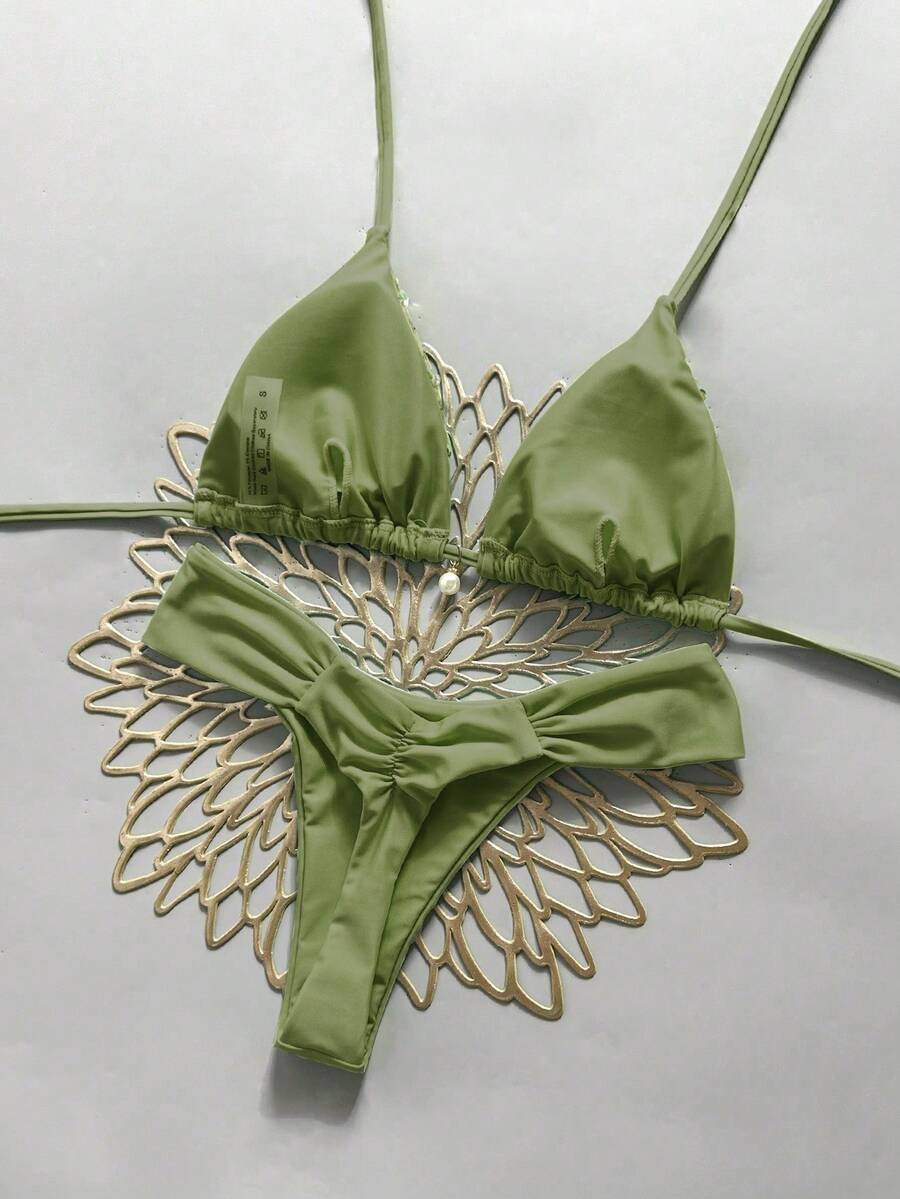 Women's 2-piece triangle cup bikini set in solid color featuring woven pearl shell decoration, halter neckline, and high-waist side-tie ruched bottoms.
