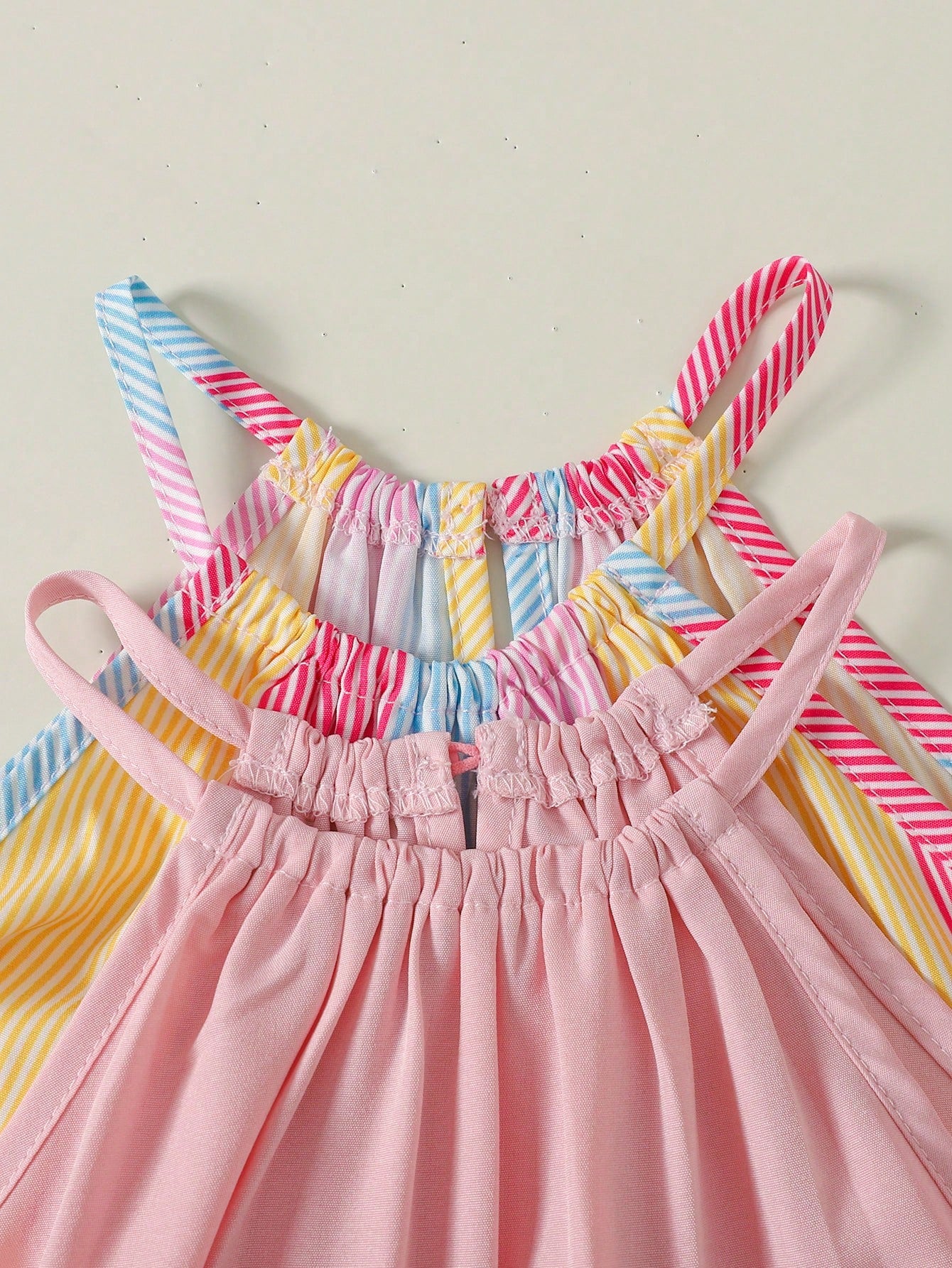 Tween girls sleeveless halter tunic dress with colorful rainbow striped colorblock pattern, button detail, short length, and regular fit for summer vacation or beach wear.
