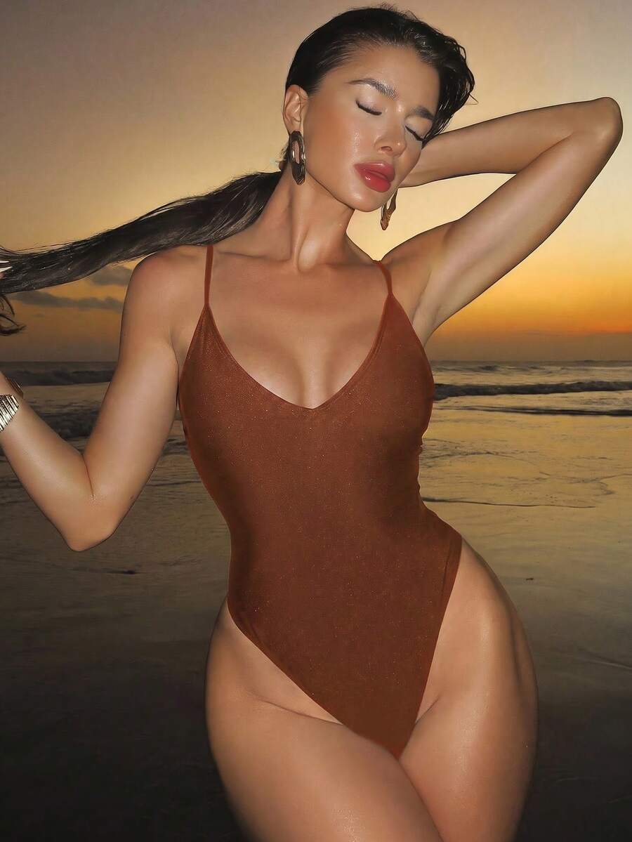 Women's black lace one-piece swimsuit featuring a deep V-neckline, spaghetti straps, backless tie-up detail, and thong bottom.