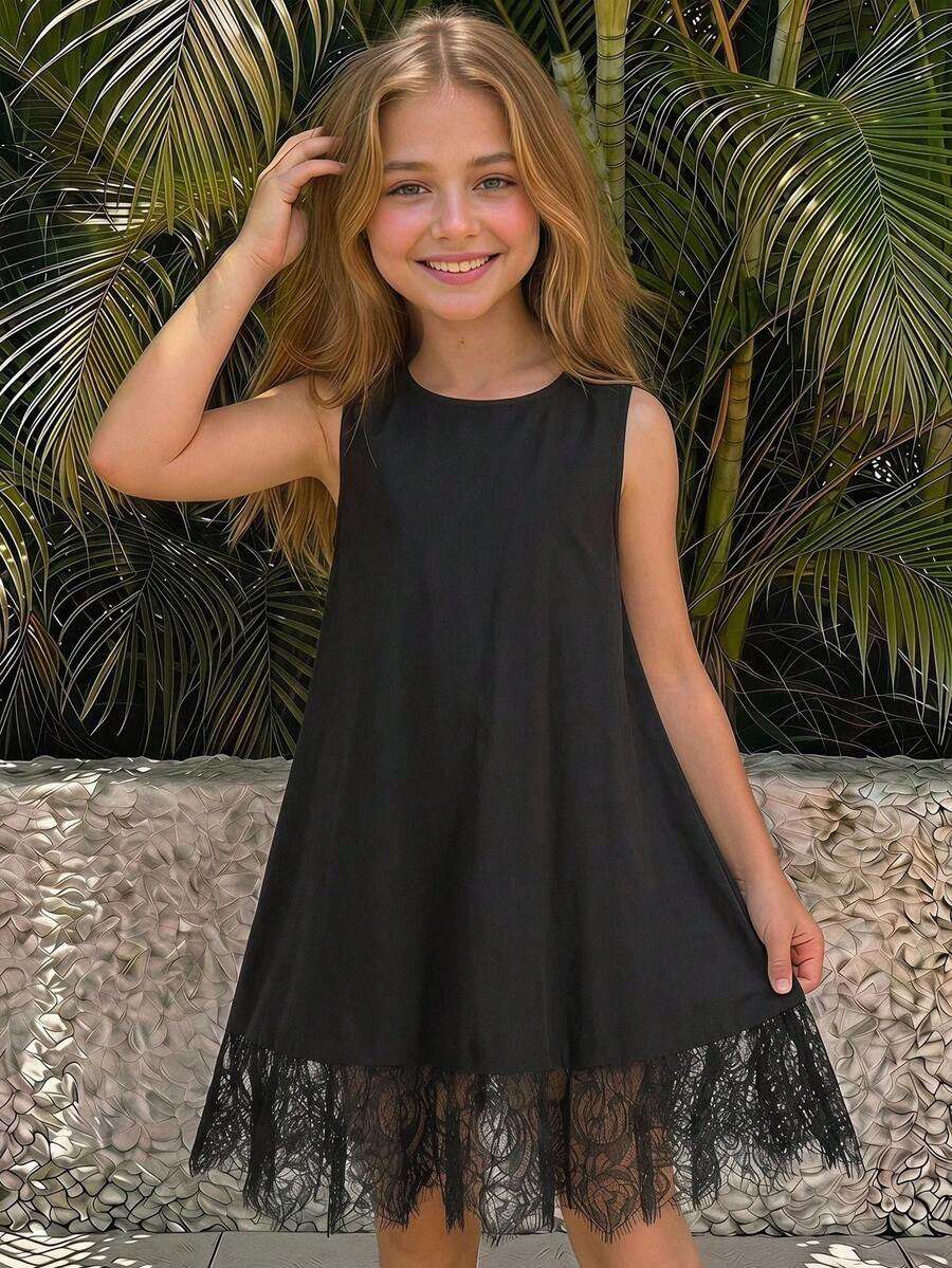 Tween girl wearing a sleeveless black tunic dress featuring a round neck, contrast lace details, and a straight hem.