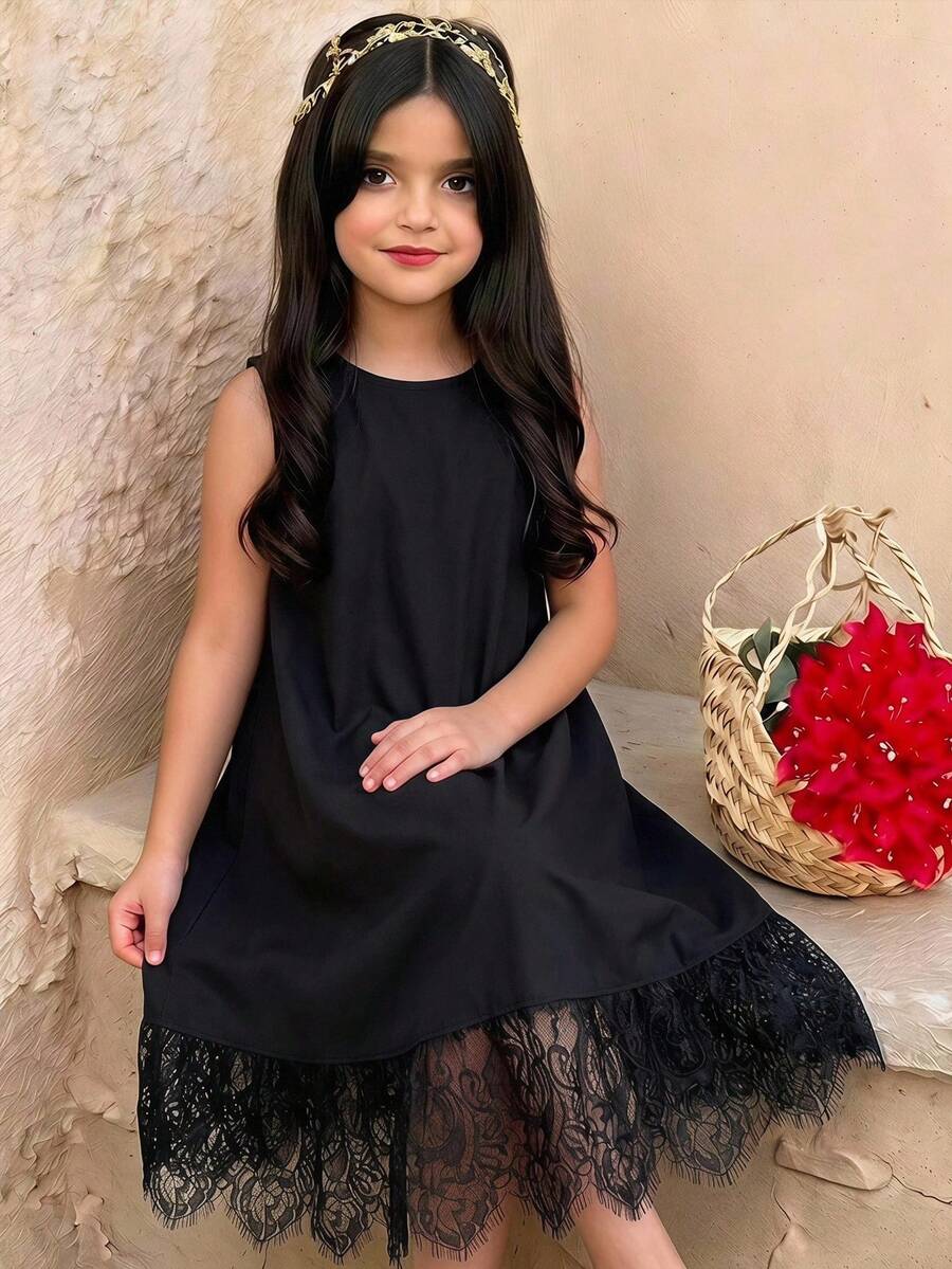 Tween girl wearing a sleeveless black tunic dress featuring a round neck, contrast lace details, and a straight hem.