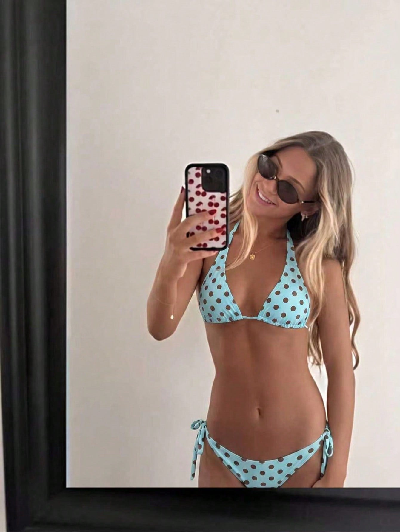 Women's polka dot two-piece bikini set featuring a backless halter top with triangle cups and matching tie-side bottoms.
