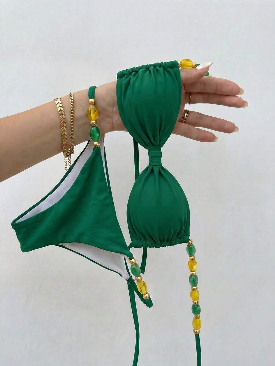 Women's green halter neck bikini set featuring color-block beaded shoulder straps, back tie detail, and high cut bottoms.