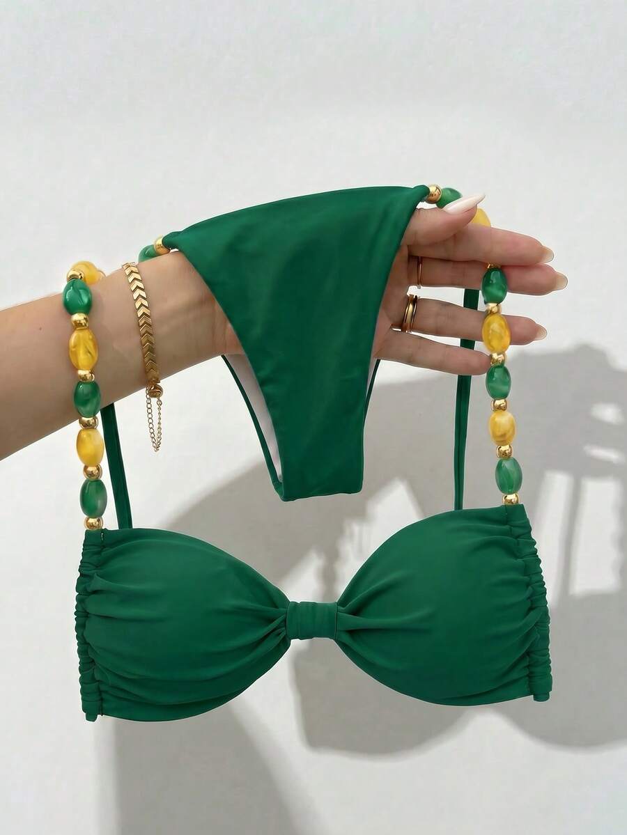 Women's green halter neck bikini set featuring color-block beaded shoulder straps, back tie detail, and high cut bottoms.
