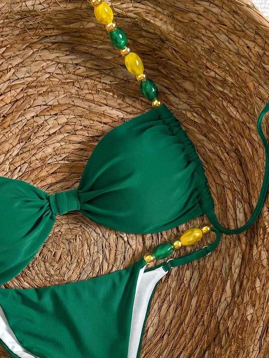 Women's green halter neck bikini set featuring color-block beaded shoulder straps, back tie detail, and high cut bottoms.
