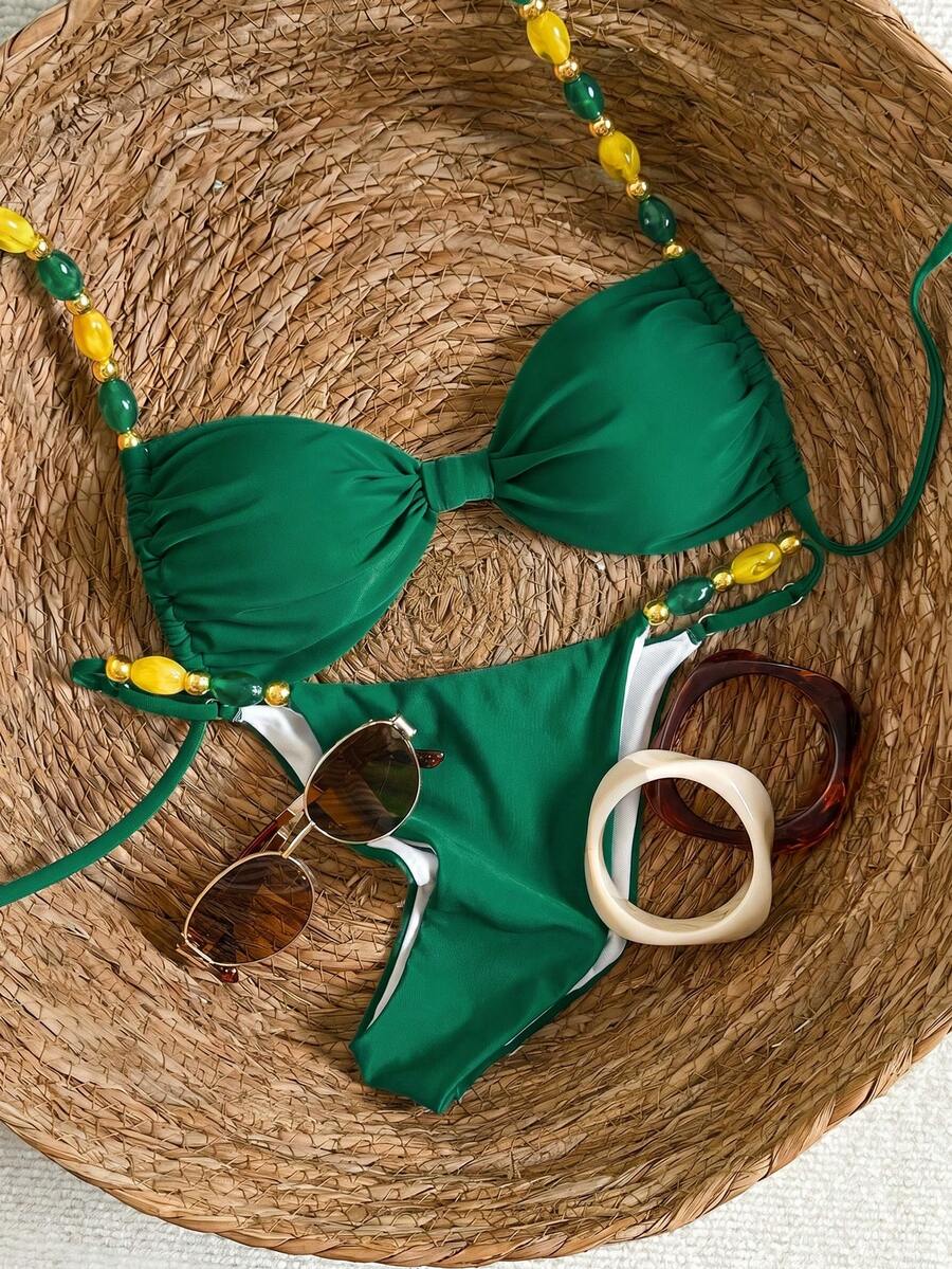 Women's green halter neck bikini set featuring color-block beaded shoulder straps, back tie detail, and high cut bottoms.