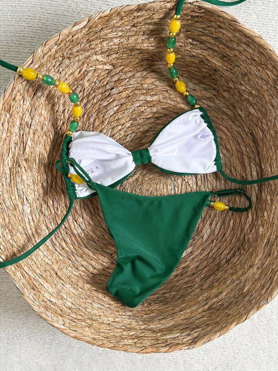 Women's green halter neck bikini set featuring color-block beaded shoulder straps, back tie detail, and high cut bottoms.