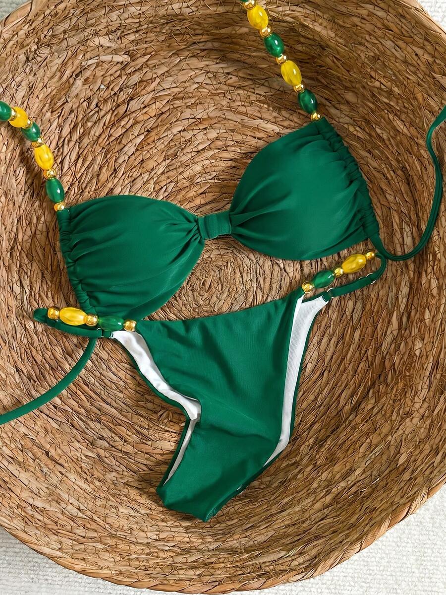 Women's green halter neck bikini set featuring color-block beaded shoulder straps, back tie detail, and high cut bottoms.