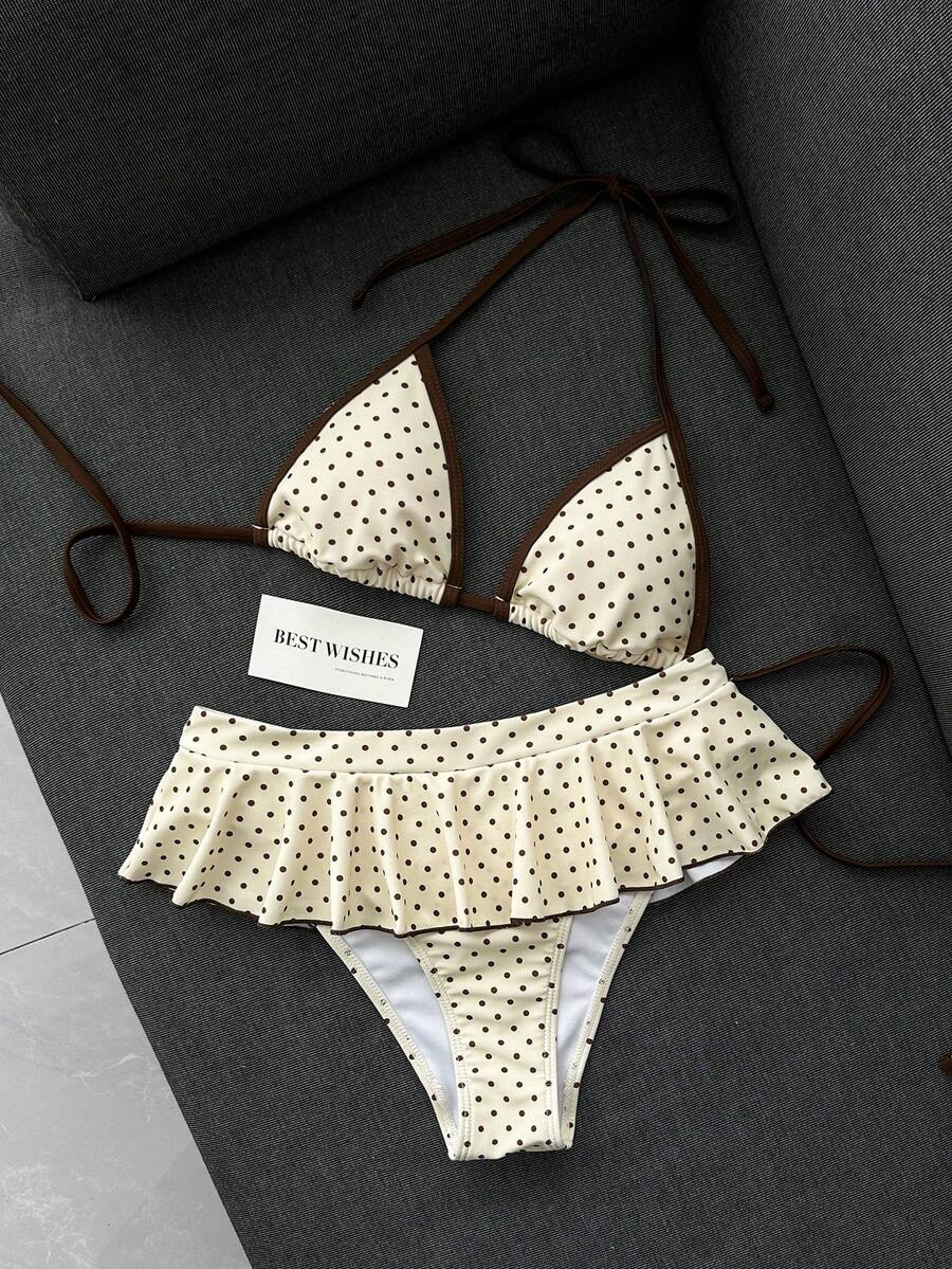 Women's 70s retro black and white polka dot bikini set featuring a halter triangle top and ultra low waist bottoms.