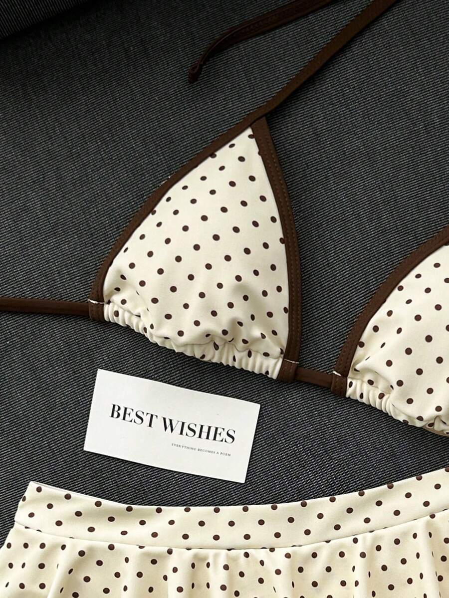 Women's 70s retro black and white polka dot bikini set featuring a halter triangle top and ultra low waist bottoms.