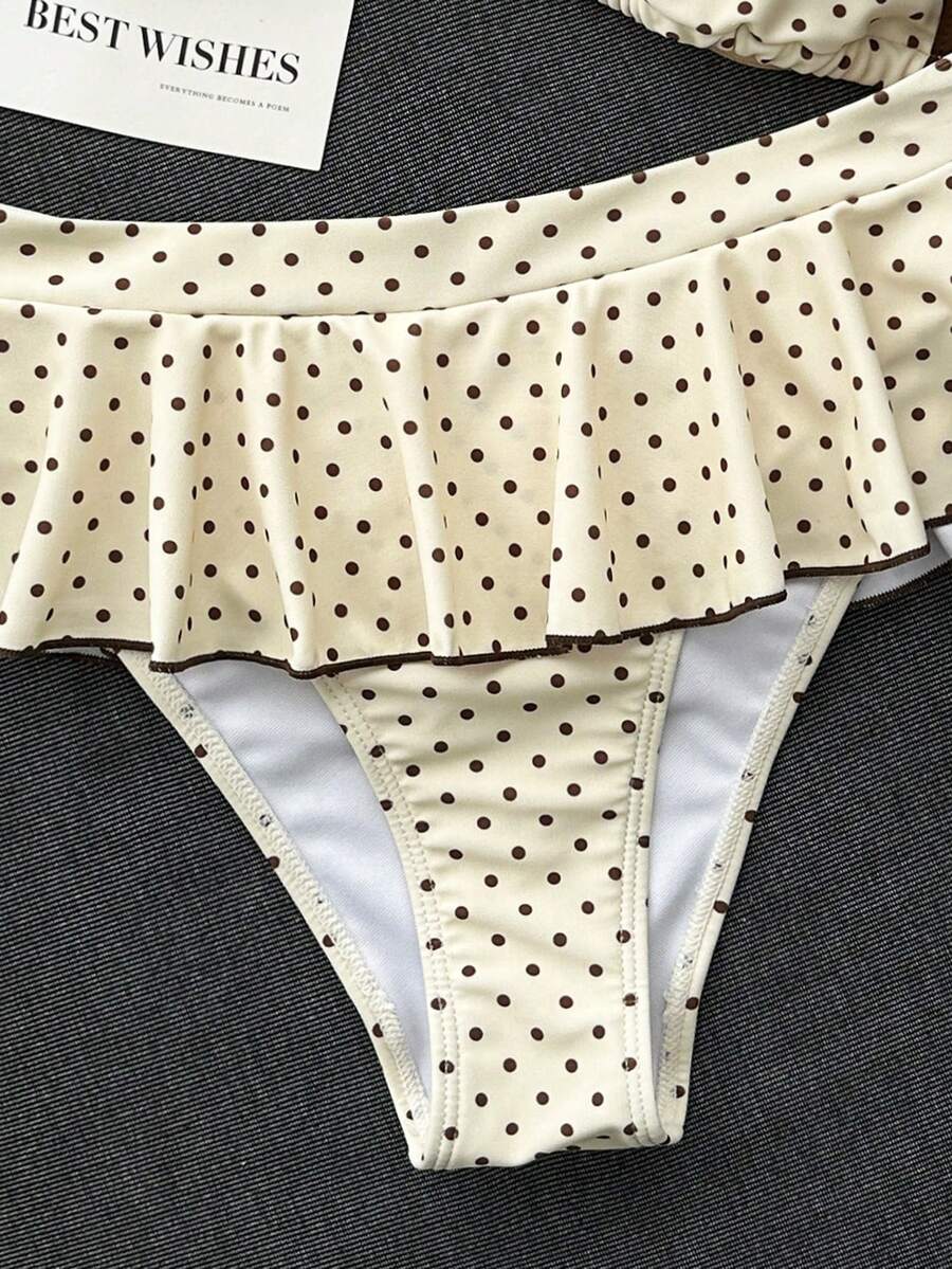 Women's 70s retro black and white polka dot bikini set featuring a halter triangle top and ultra low waist bottoms.