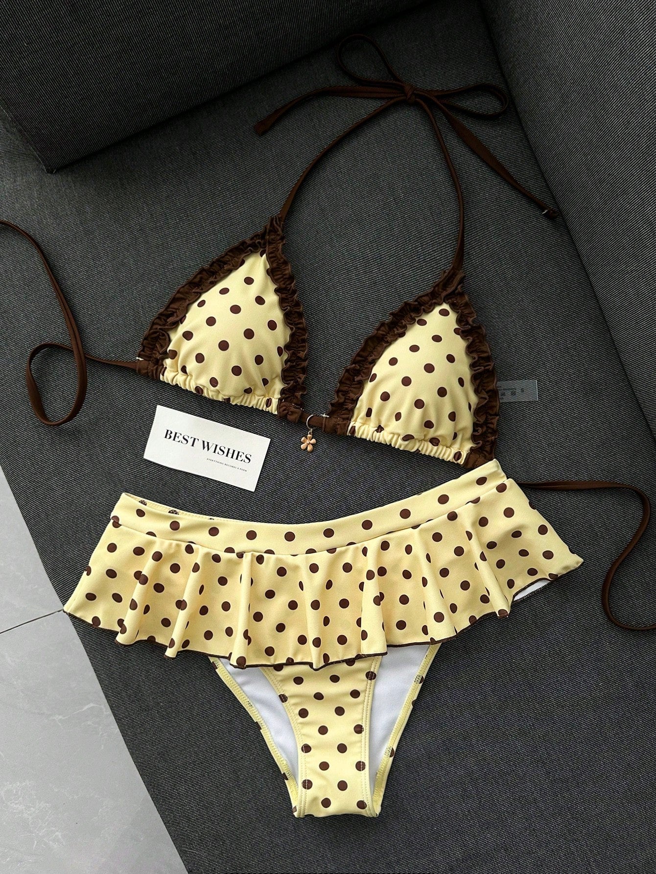 Women's 70s retro black and white polka dot bikini set featuring a halter triangle top and ultra low waist bottoms.