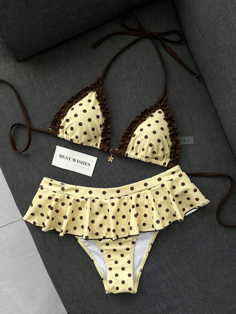Women's 70s retro black and white polka dot bikini set featuring a halter triangle top and ultra low waist bottoms.