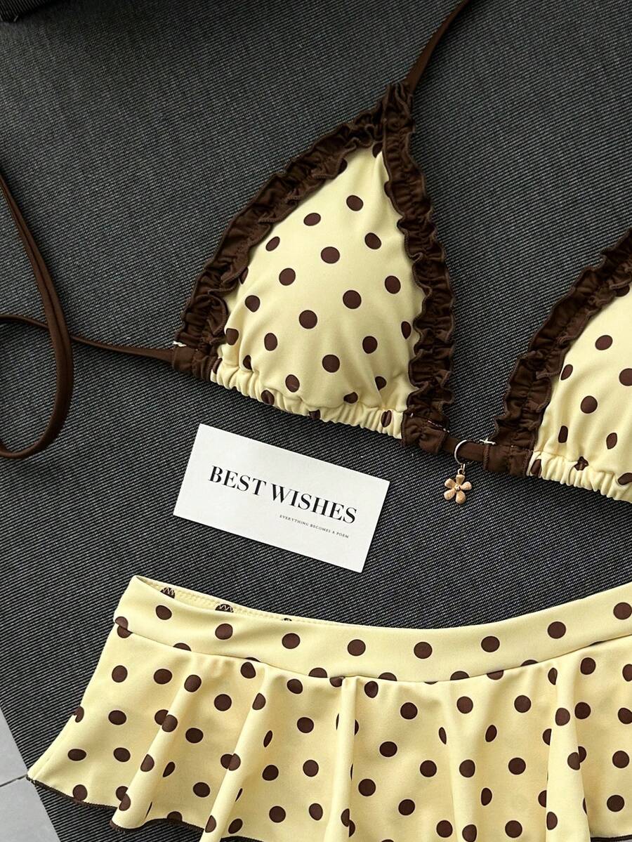 Women's 70s retro black and white polka dot bikini set featuring a halter triangle top and ultra low waist bottoms.