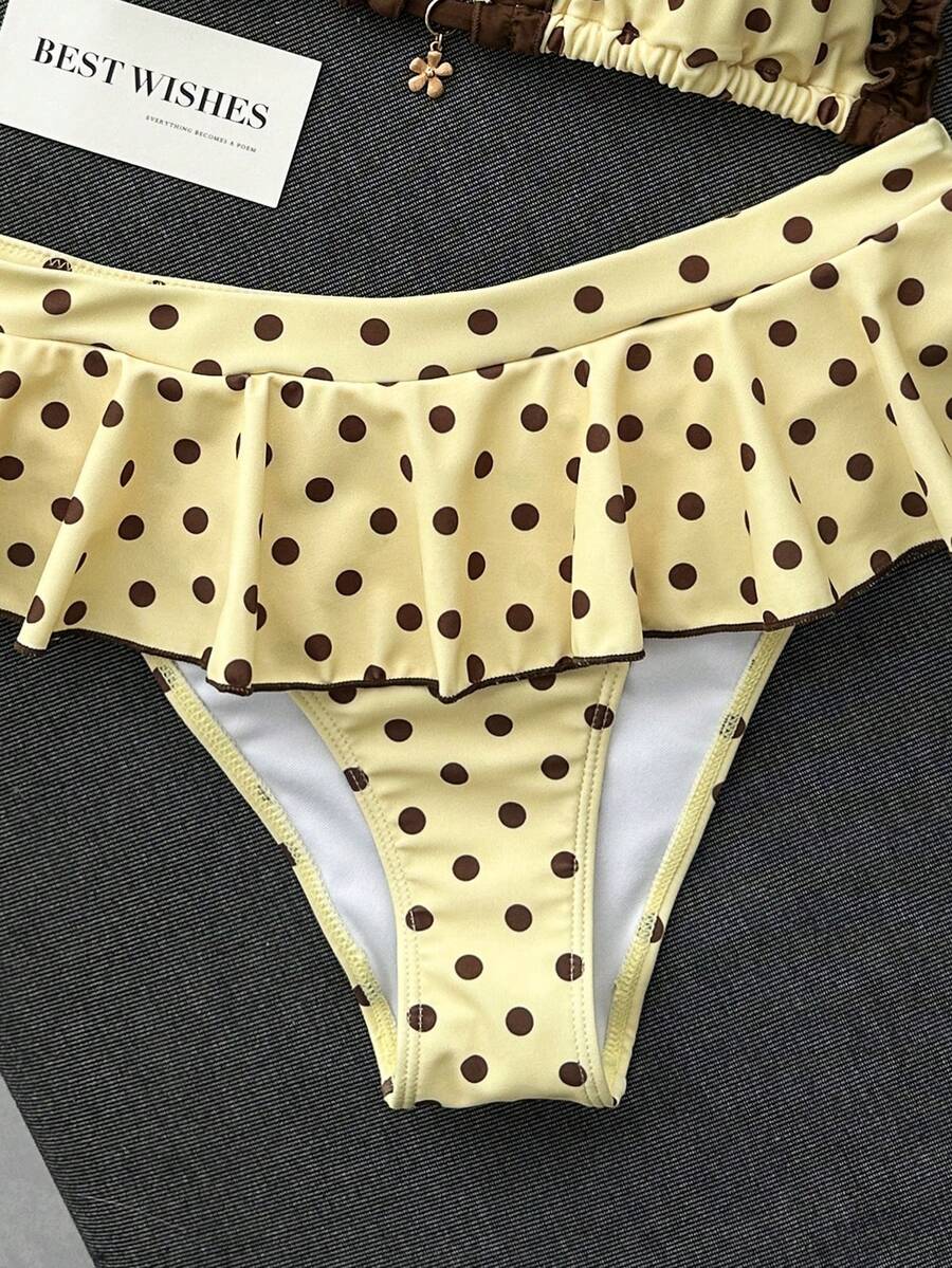 Women's 70s retro black and white polka dot bikini set featuring a halter triangle top and ultra low waist bottoms.