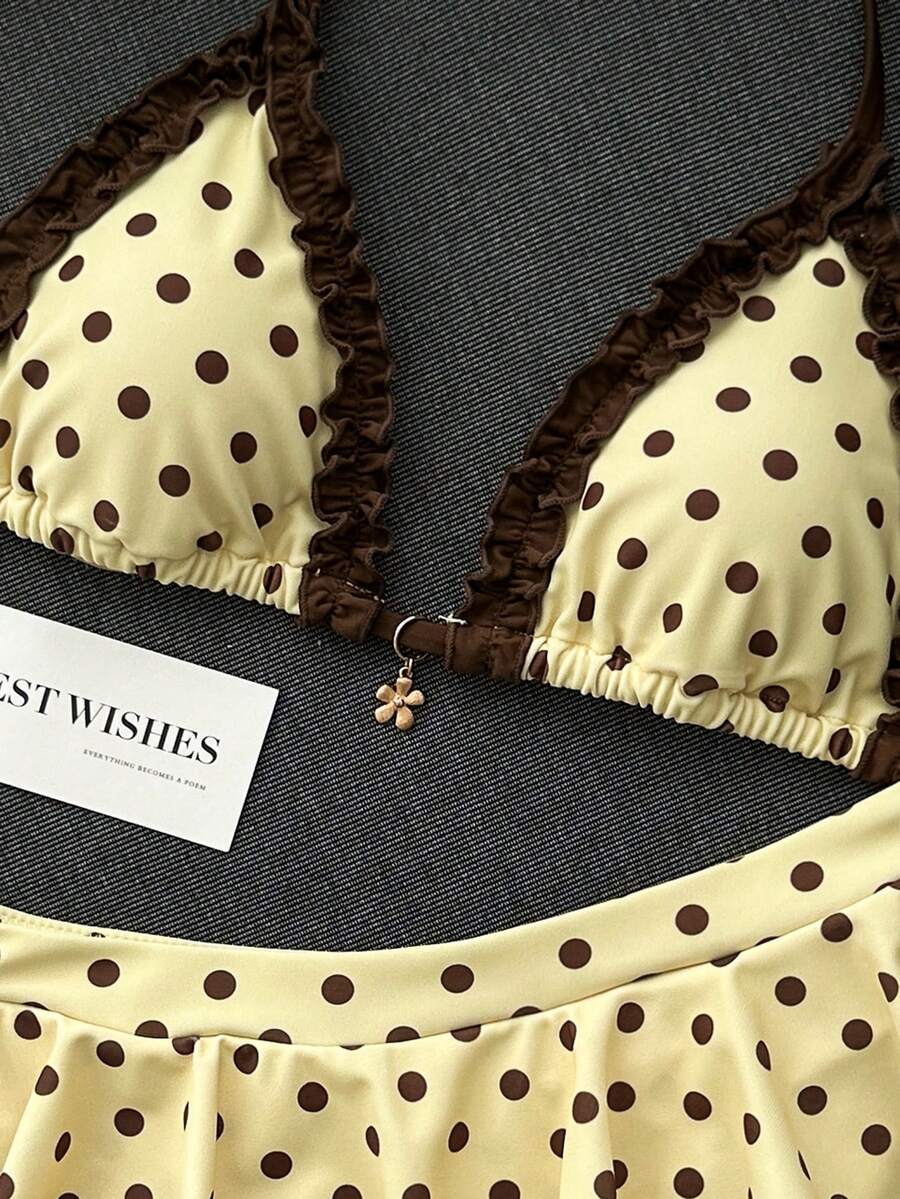 Women's 70s retro black and white polka dot bikini set featuring a halter triangle top and ultra low waist bottoms.